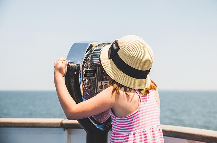 girl looking out over bay through viewfinder