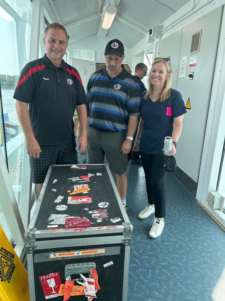 Left Howie, Middle Walt The Hall of Fame Cup Keepers and Katy Boettinger on the right. In front of them is the Stanley cup within its travel case.