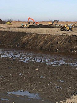 dump trucks at the contained disposal facility near the Cape May ferry