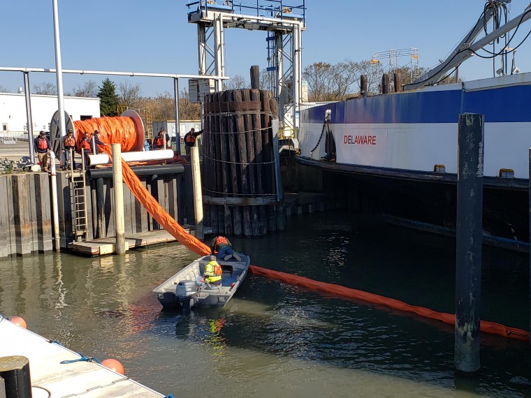 Ferry employees running a containment line during an oil spill practice drill