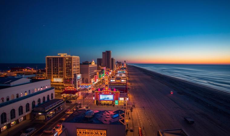 sun setting on the shore in Atlantic City with the casinos skyline lighting up 