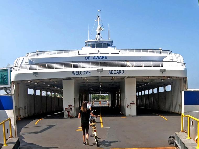 A passenger walks their bicycle onto the Cape May - Lewes Ferry Car Deck