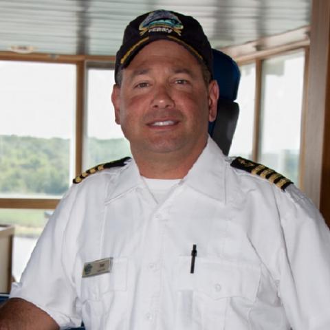 Head shot of Captain Joe Napoleon in uniform along with a black Cape May - Lewes Ferry cap