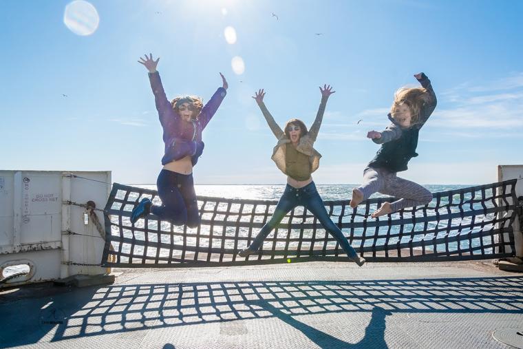 Three women jumping for joy aboard the Cape May-Lewes Ferry