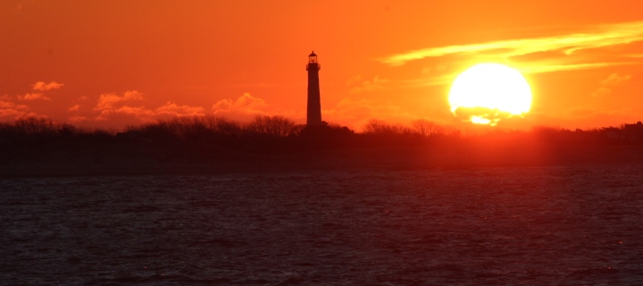 Lighthouse backlit by the rising sun