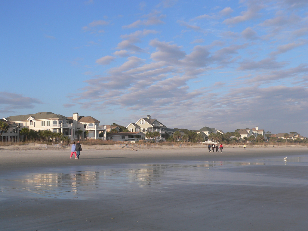 Beachgoers walk along the sand