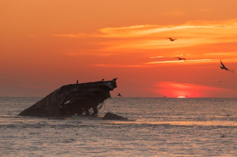 sunset over the sunken concrete ship