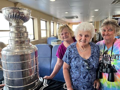 Ferry passengers Kathy, Angel, and Toni posing with Stanley Cup