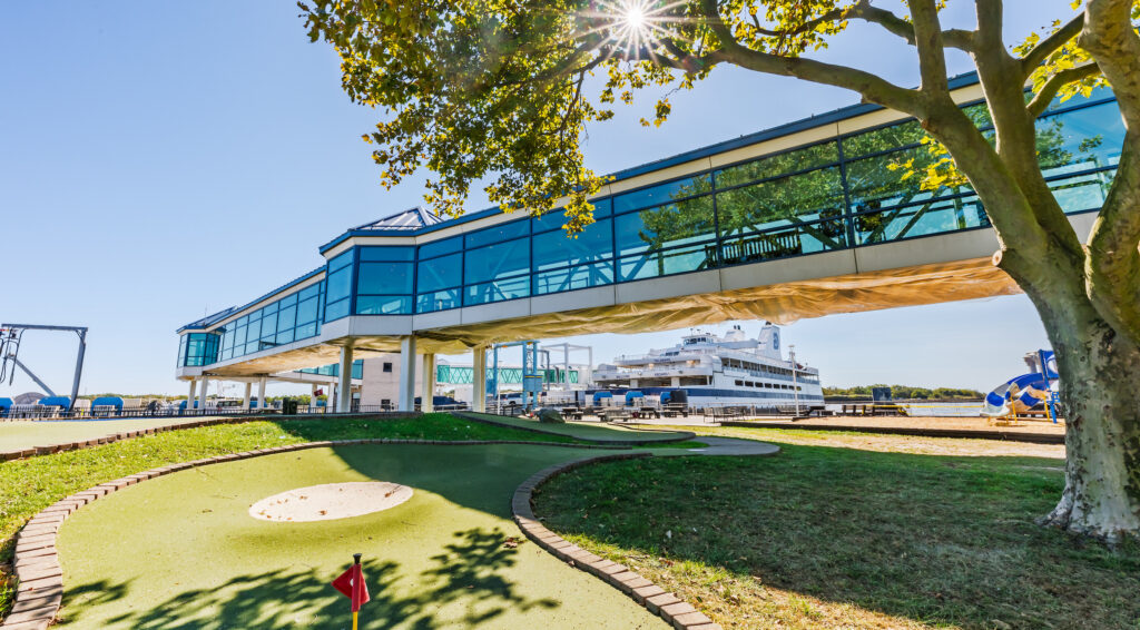 The Cape May - Lewes Ferry Cape May Terminal Grounds in the foreground with the mini-golf course, skywalk and the ferry docked in the background on a spring day.