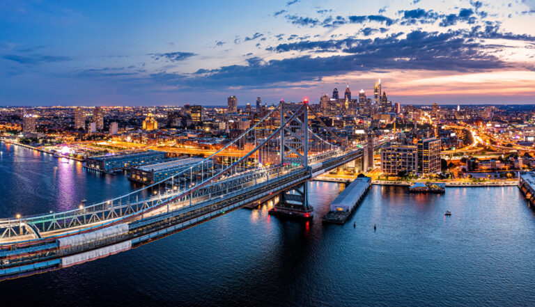 A view of the Philadelphia Skyline from above Camden NJ with the Ben franklin bridge in the foreground at Sunset