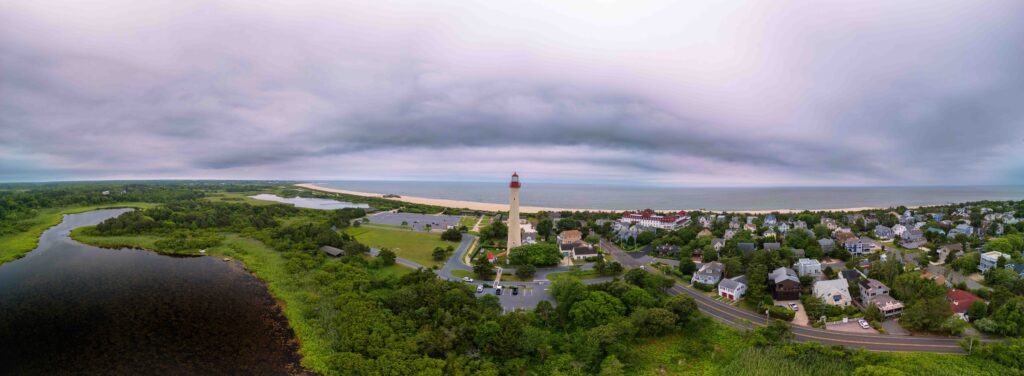 An aerial panoramic image including the path along the Cape May Shoreline Ride near Historic Cold Spring Village, NJ, part of the 46-mile signed coastal route connecting Cape May Lighthouse through surrounding bird sanctuaries and coastal towns.