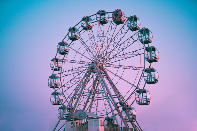 The Steel Pier Observation Wheel rises above the Atlantic City Boardwalk under a colorful sky.