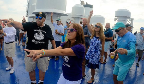 A lady in a purple shirt dances in the crowd during Rock the Boat