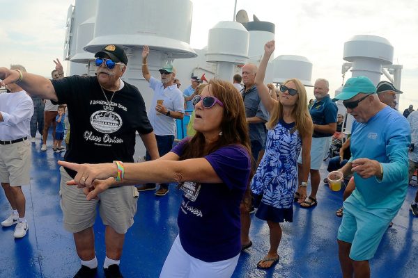 A lady in a purple shirt dances in the crowd during Rock the Boat