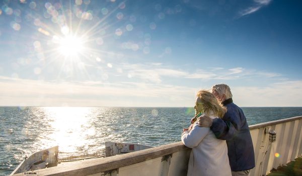 Couple looking out over the sunny view during the winter season