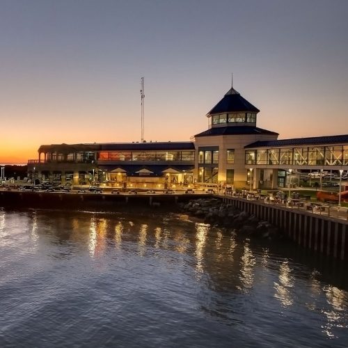 Photo of the Cape May Ferry Terminal at dusk from the Ferry, lights reflecting on the water